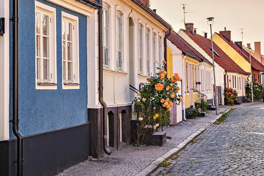 Färgglada bostadshus längs en kullerstensgata
